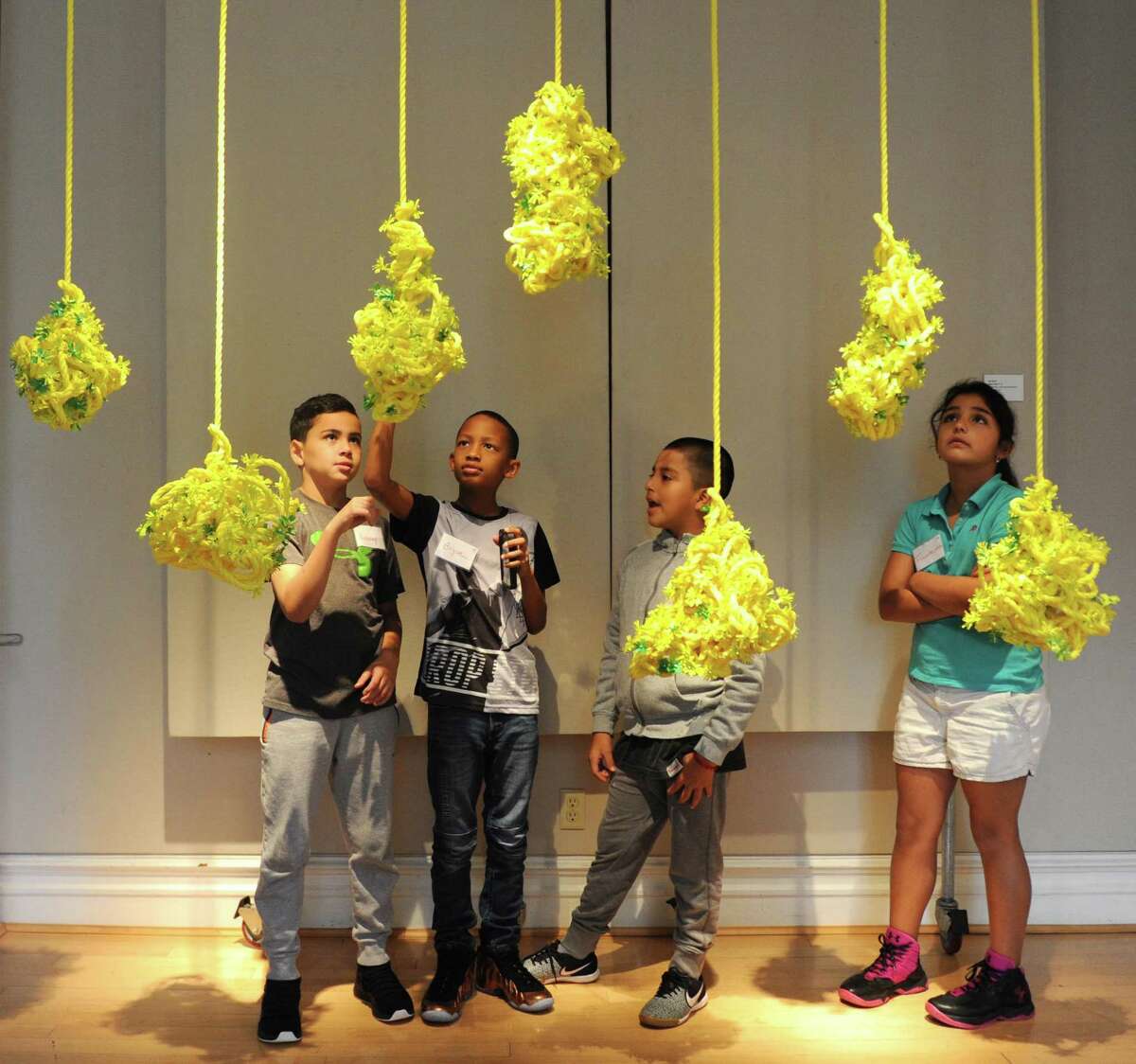 New Lebanon School fourth-graders, from left, Anthony Goncalves, Bryce Seward, Alexis Sarango, and Fransheska Rojas look at Eve Suter's piece "Ropes Cloud (1-7)" as part of the Youth@Art program at the Greenwich Arts Council's Bendheim Gallery in Greenwich, Conn. Wednesday, Oct. 25, 2017. The Bendheim Gallery's exhibition "Flower Stories" featuring contemporary artists' perception of flowers in a variety of mediums will run through Nov. 15.
