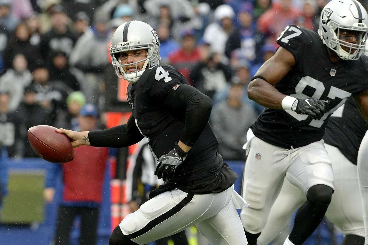 Oakland Raiders quarterback Derek Carr rolls out after faking a handoff during the first half of an NFL football game against the Buffalo Bills, Sunday, Oct. 29, 2017, in Orchard Park, N.J. (AP Photo/Adrian Kraus)