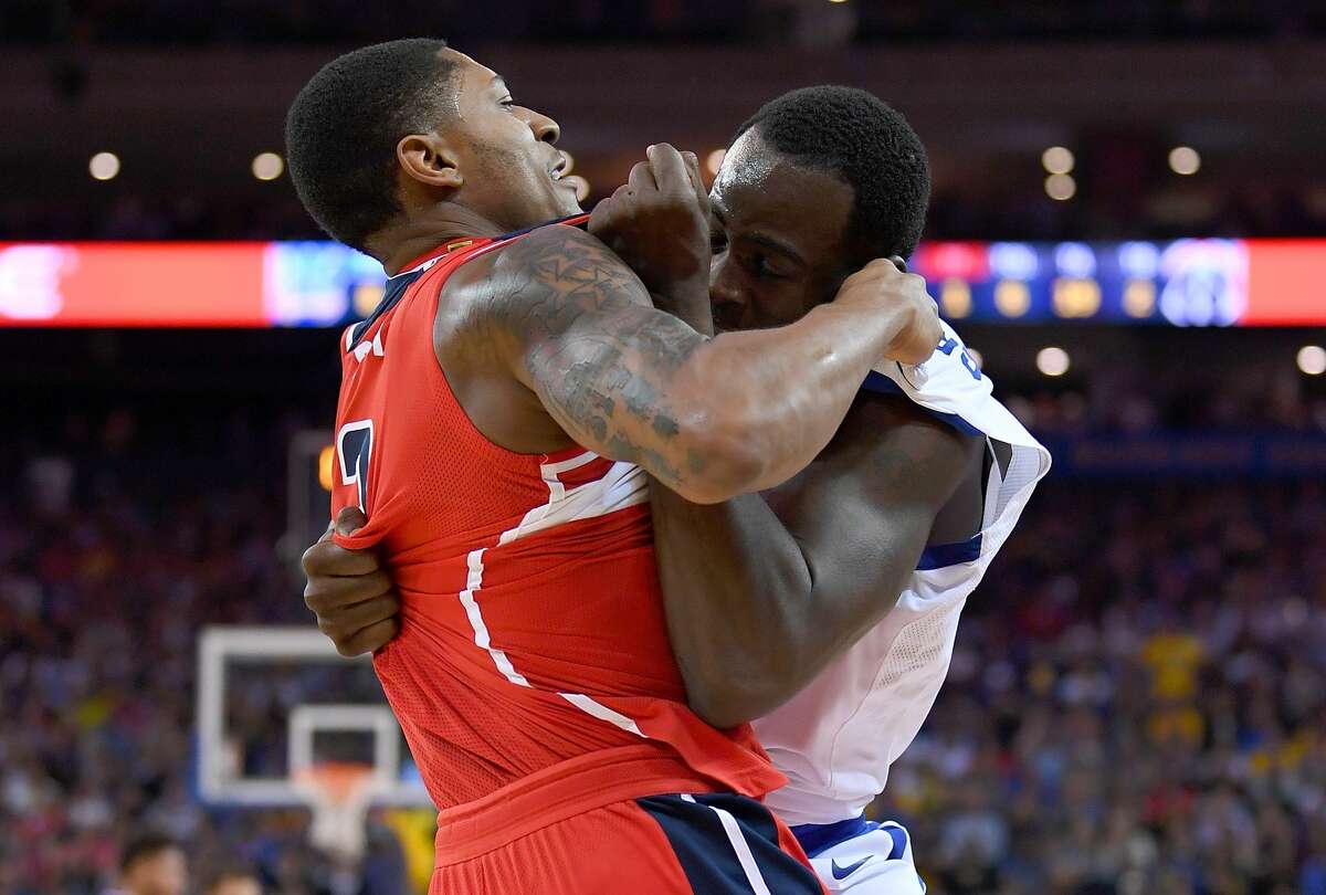  Draymond Green #23 of the Golden State Warriors and Bradley Beal #3 of the Washington Wizards gets tangled up in a fight during the second quarter of their NBA basketball game at ORACLE Arena on October 27, 2017 in Oakland, California. 