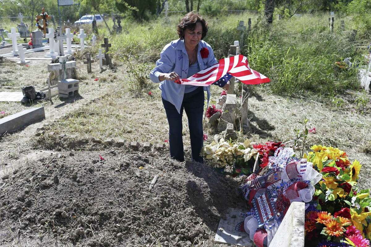 Estela Hernandez, 69, of Rio Grande City, visits her parents' grave at Santa Rosalia Cemetery in Brownsville, Texas, Thursday, Oct. 26, 2017. The cemetery served a long-gone ranching community and is situated behind the U.S.-Mexico border wall.