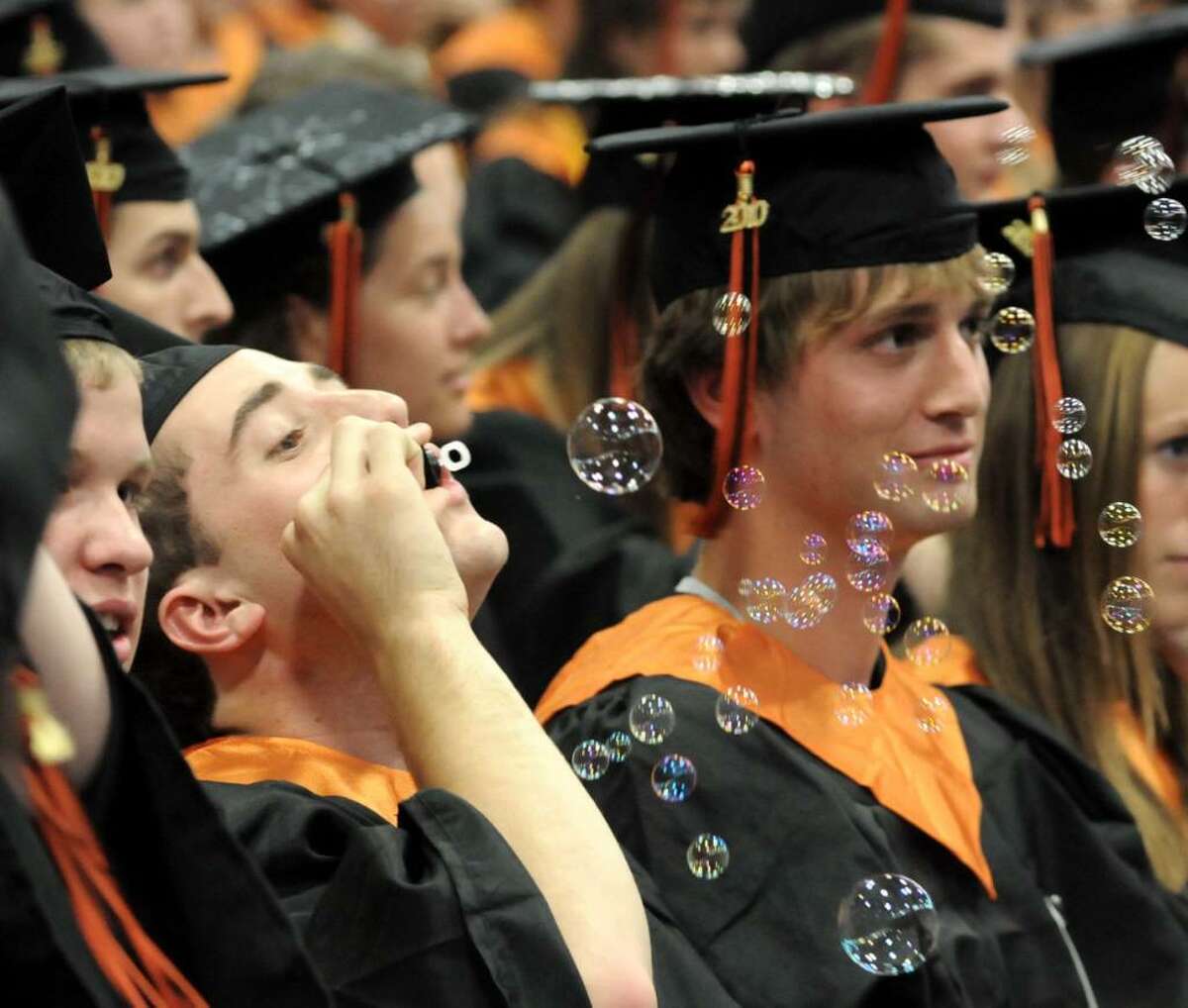 Ridgefield High School graduates blow bubbles while they wait for their turn to get their diplomas at the Western Connecticut State University O'Neill Center on Friday June 25, 2010 during their commencement ceremony. From left, Steven Montanari, John Morrison and Duncan Morrissey.