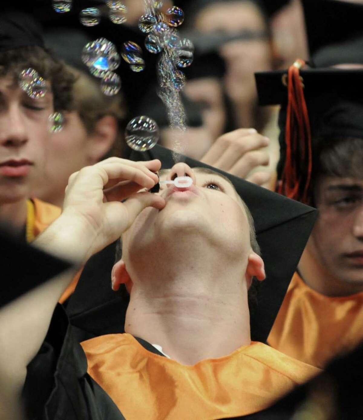 John Morrison, a Ridgefield High School graduate, blows bubbles while he waits for his turn to get his diploma. The graduation took place at the Western Connecticut State University's O'Neill Center on Friday June 25, 2010.