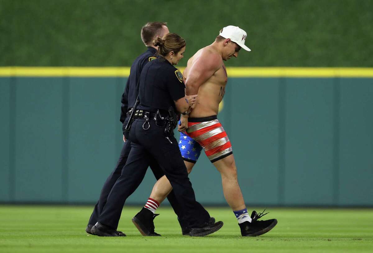 HOUSTON, TX - OCTOBER 29: Security apprehends a fan running on the field during game five of the 2017 World Series between the Houston Astros and the Los Angeles Dodgers at Minute Maid Park on October 29, 2017 in Houston, Texas.