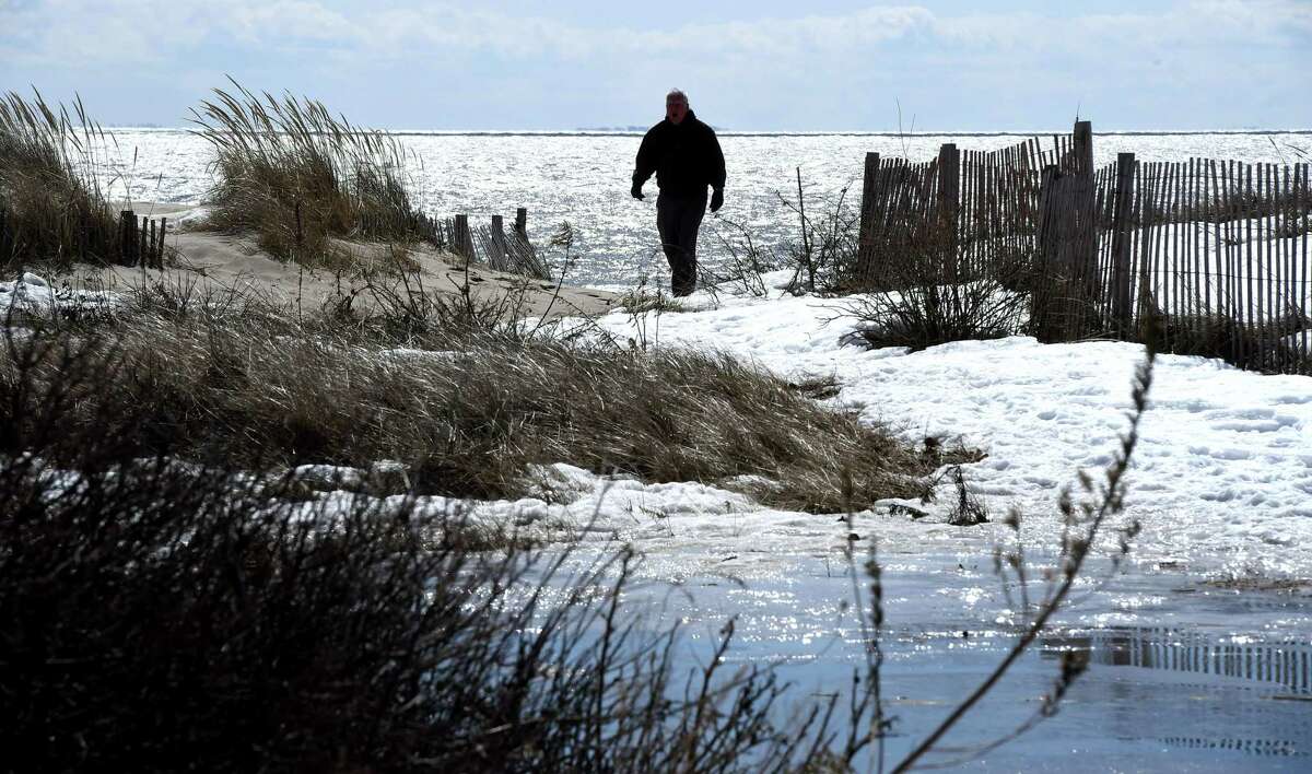 (Arnold Gold-New Haven Register) Bob Phoenix of Essex cuts his walk short because of the wind and ice at Hammonasset Beach State Park's West Beach in Madison on 3/18/2015.