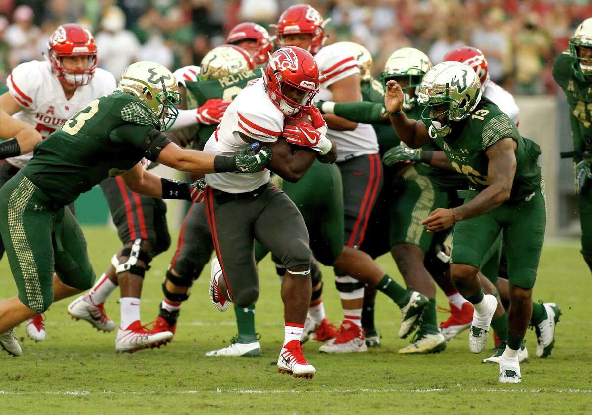 TAMPA, FL - OCTOBER 28: Running back Mulbah Car #34 of the Houston Cougars runs for a first down between linebacker Auggie Sanchez #43 of the South Florida Bulls and safety Tajee Fullwood #13 during the third quarter of an NCAA football game on October 28, 2017 at Raymond James Stadium in Tampa, Florida. (Photo by Brian Blanco/Getty Images)