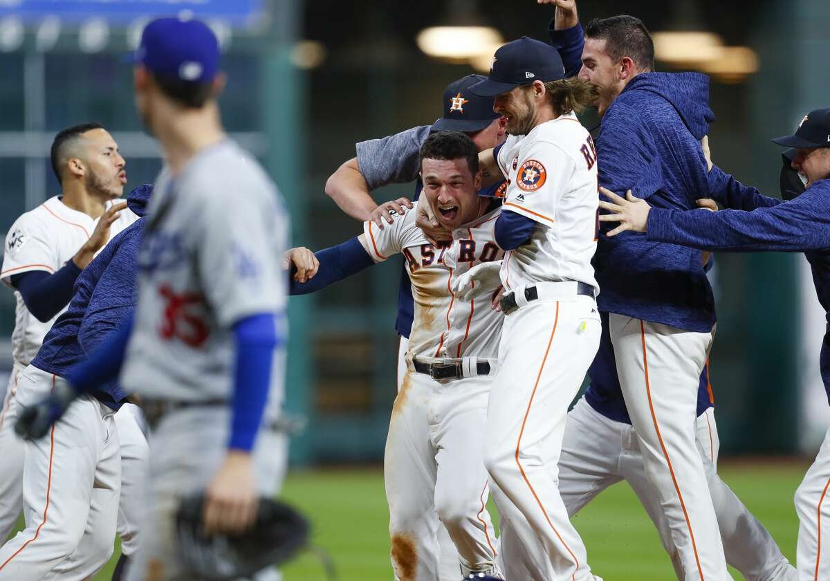 Houston Astros third baseman Alex Bregman (2) is surrounded by his teammates after hitting a walk off single that drove in left fielder Derek Fisher (21) to give the Astros a 13-12 victory over the Los Angeles Dodgers in the tenth inning of Game 5 of the World Series at Minute Maid Park on Monday, Oct. 30, 2017, in Houston.