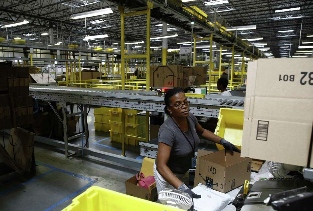 In this Aug. 3, 2017, photo, Myrtice Harris packages products for shipment at an Amazon fulfillment center in Baltimore. Some 94 percent of customers worldwide are shopping online, according to a new Pitney Bowes study.