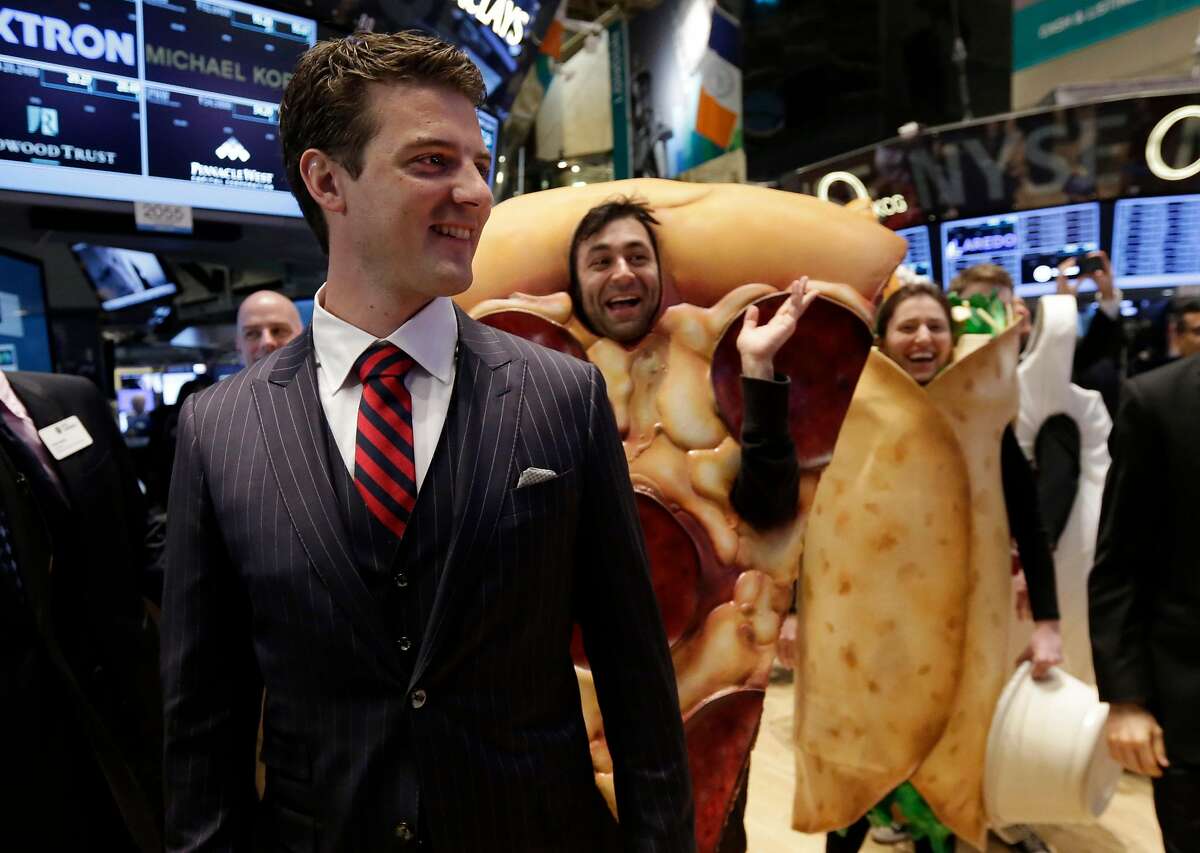 GrubHub Inc. CEO Matthew Maloney, trailed by costume characters, walks the New York Stock Exchange trading floor before his company's IPO begins trading, Friday, April 4, 2014. Investors sent shares of the online food ordering service up 51 percent to $39.20 in early trading in its stock market debut Friday. (AP Photo/Richard Drew)
