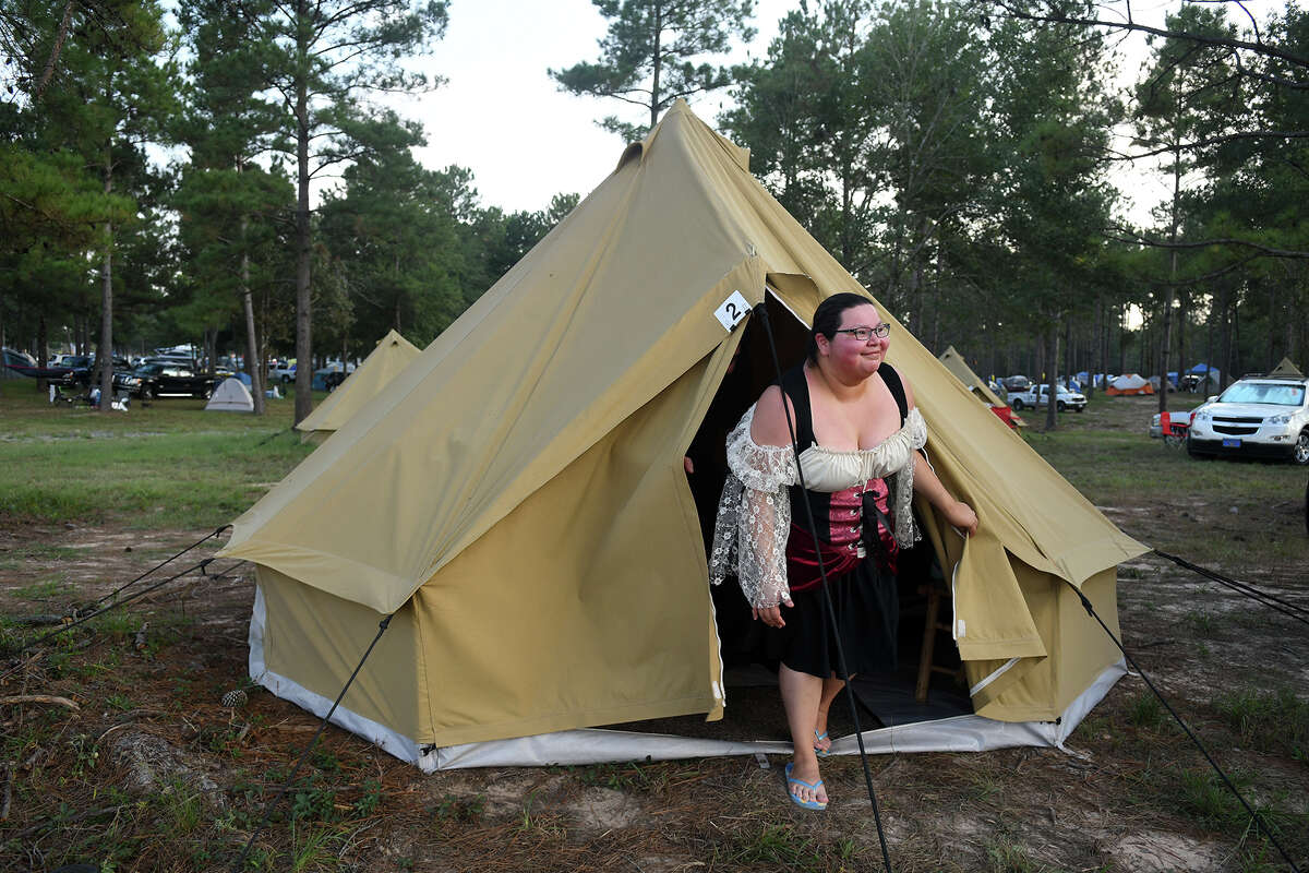 Melissa Puente, of San Antonio, checks out a visitor to her tent while camping with her husband Henry in the new Glamalot camping area at the Texas Renaissance Festival.