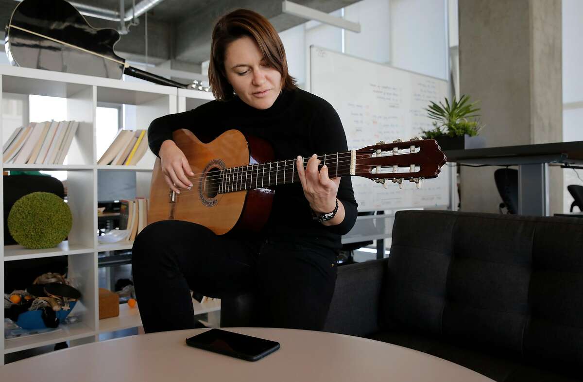Eugenia Kuyda,CEO of Replika, takes a break to play guitar at their office in San Francisco, Ca. on Monday October 30, 2017. Replika a San Francisco start up that is offering people an unusual use of artificial intelligence, an app you train to know you, to mirror your voice, responses, speech patterns, likes and dislikes to become your digital confidant.