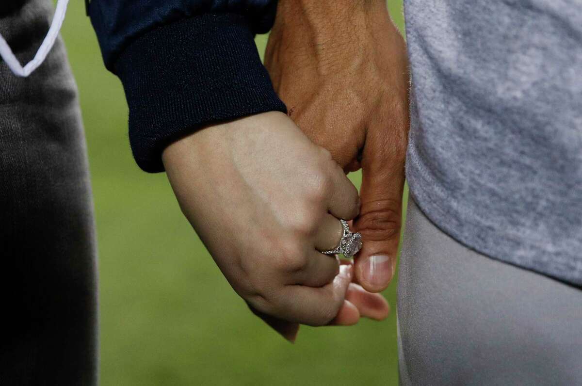 Daniella Rodriguez wearing her engagement ring, holds hands with Houston Astros' Carlos Correa after Game 7 of baseball's World Series Wednesday, Nov. 1, 2017, in Los Angeles. The Astros won 5-1 to win the series 4-3. Correa proposed to Rodriguez after the game. (AP Photo/Jae C. Hong)