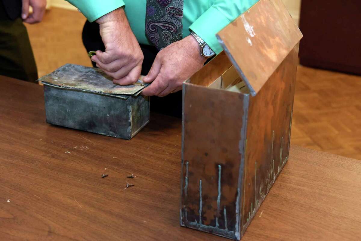 Tim Haskins, project manager with United Group of Companies, removes screws from a copper time capsule box at the Rensselaer County Historical Society on Thursday, Nov. 2, 2017, in Troy, N.Y. The time capsule was in a stone in a building that was the former Immaculate Conception seminary. On the right is another time capsule, from 1960 found inside another stone in the building complex. The College Suites at Hudson Valley were built on the site. (Paul Buckowski / Times Union)