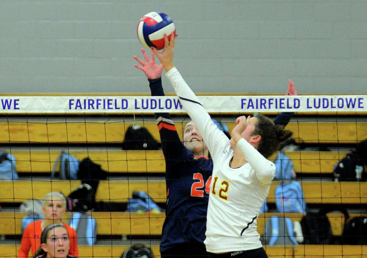 St. Joseph's Christina Crocco (12) taps the ball over the net as Danbury's Catrina Sullivan looks to block during FCIAC girls volleyball semifinal action in Fairfield, Conn., on Thursday Nov. 2, 2017.