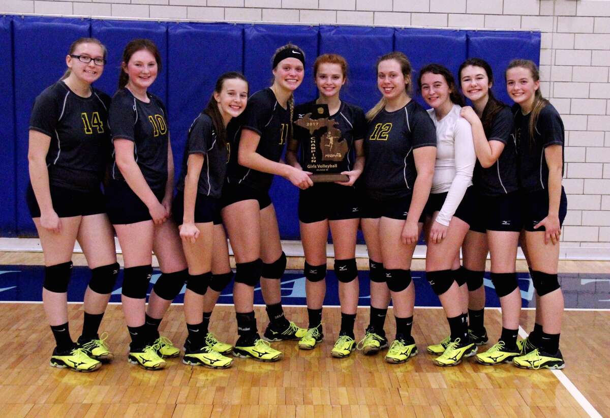 Members of the North Huron volleyball team pose with the Class D district championship trophy after defeating Caseville Thursday night in Bay City. It’s the second straight district title for the Warriors. (Chip Burch/Huron Daily Tribune)