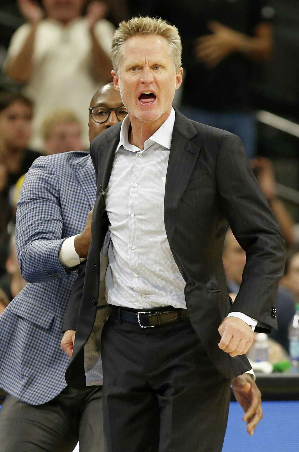 Golden State Warriors assistant coach Mike Brown (left) holds back head coach Steve Kerr as he reacts after a play during first half action against the San Antonio Spurs Thursday Nov. 2, 2017 at the AT&T Center. Kerr was given a technical.