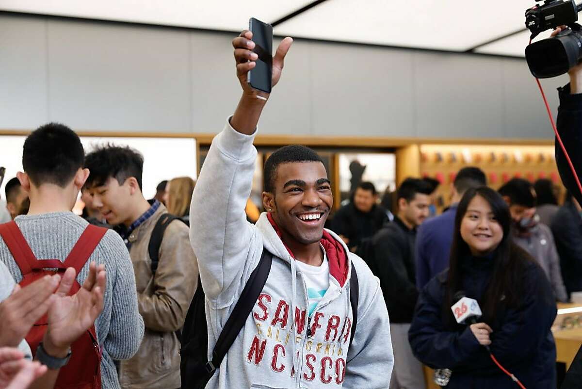A man holds up an iPhone X and smiles after purchasingt it on launch day at the Apple Store Union Square on November 3, 2017, in San Francisco, California. Apple's flagship iPhone X hits stores around the world as the company predicts bumper sales despite the handset's eye-watering price tag, and celebrates a surge in profits.