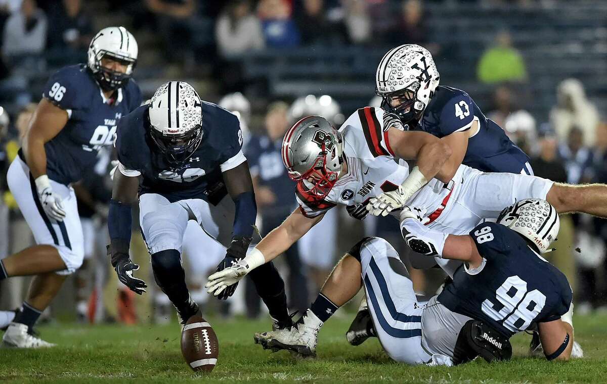 Brown tight end Anton Casey is able to recover a fumble against Yale defensive end Kyle Mullen (98), John Dean (43) and Foyesade Oluokun (23) on Friday under the lights at the Yale Bowl.