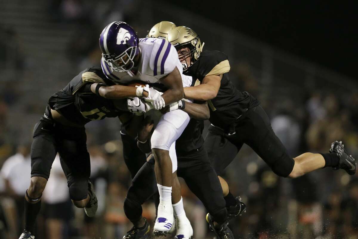 Angleton Wildcats Tamerik Williams (21) carries Foster Falcons defenders on a gain in the second half during the high school football game between Angleton Wildcats and the Foster Falcons in Rosenberg, TX on Friday, November 03, 2017. The Wildcats defeated the Falcons 34-7.