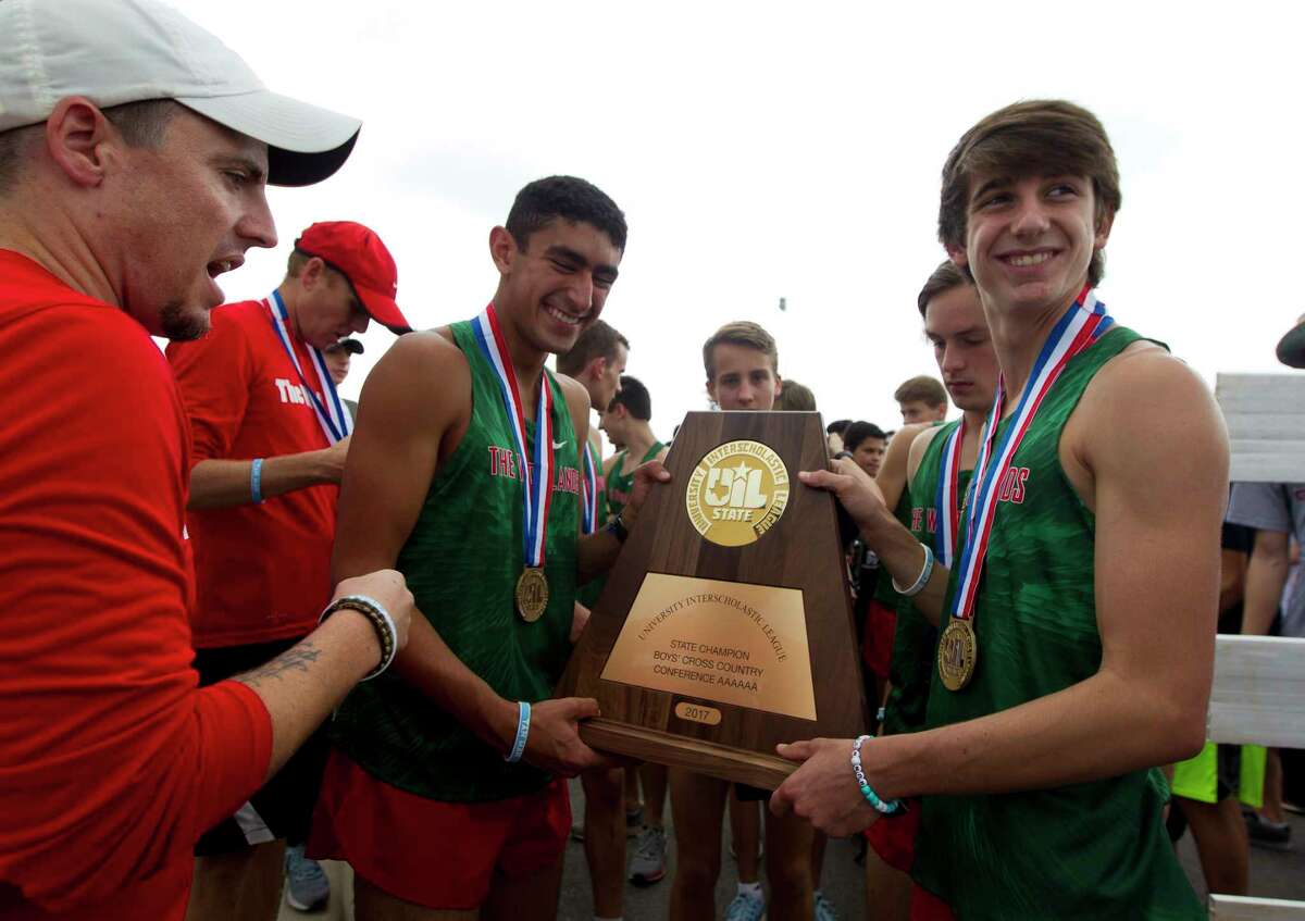 Runners with The Woodlands High School, including second overall finsher Gavin Hoffpauir (right), gather around the team's new trophy after winning the program’s third straight team title and 20th overall during the UIL State Cross Country Championships at Old Settlers Park, Saturday, Nov. 4, 2017, in Round Rock.