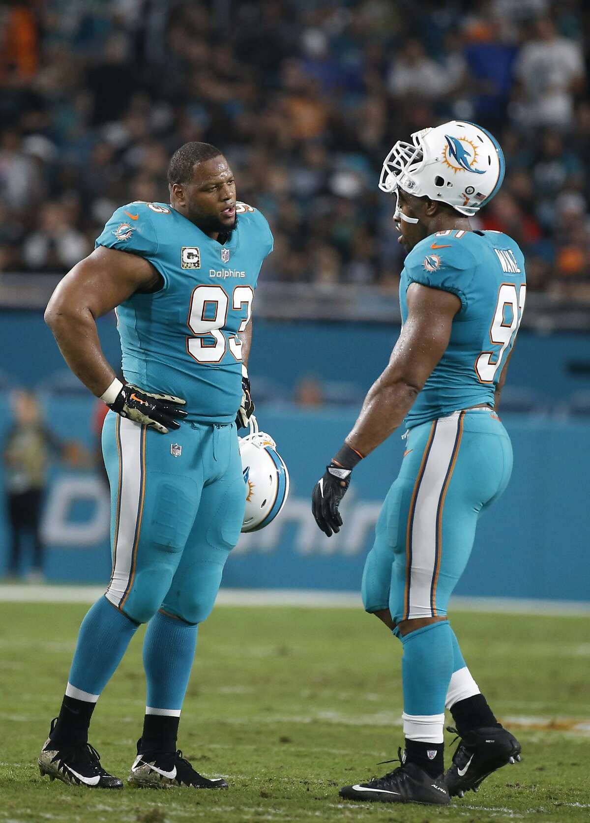 Miami Dolphins defensive tackle Ndamukong Suh (93) talks to Miami Dolphins defensive end Cameron Wake (91), during the first half of an NFL football game against the Oakland Raiders, Sunday, Nov. 5, 2017, in Miami Gardens, Fla. (AP Photo/Wilfredo Lee)