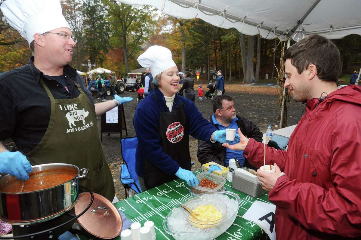 Brian and Erin Ash smile as they serve their Ash Family Chili during the 10th Annual Stamford Charity Chili Cookoff at the Stamford Museum and Nature Center on Sunday.