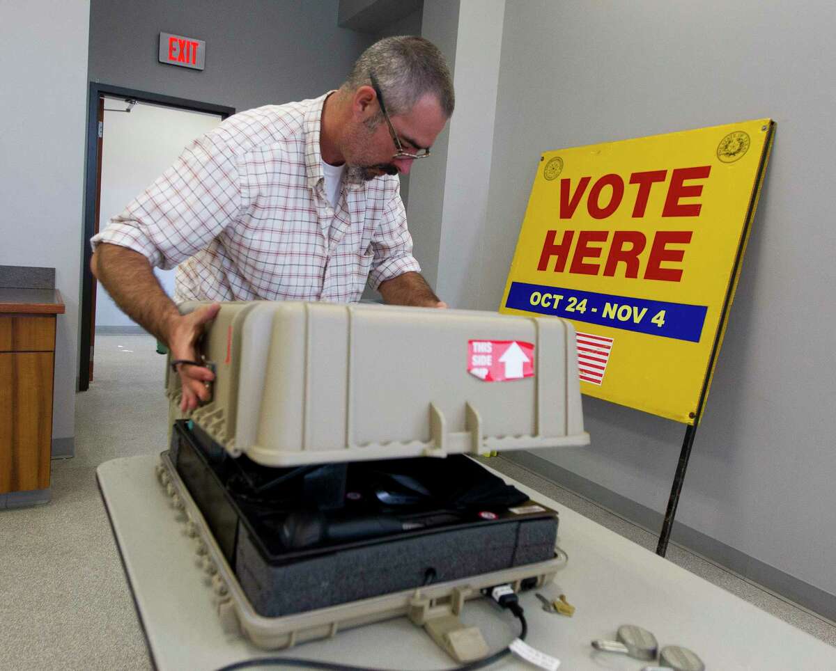 Rick Nusz, election equipment manager with Montgomery County, unloads voting equipment at the Lone Star Community Center prior to the start of early voting on Oct. 23 in Montgomery.