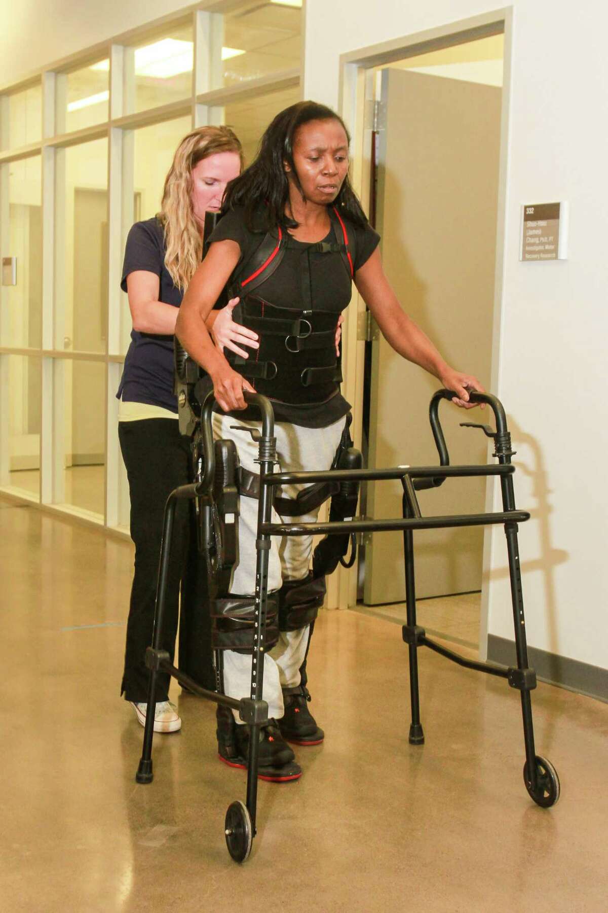 Physical therapist Erin Edenfield, left, aids Vikki McFarland, a study participant, in getting up to walk, wearing a Ekso wearable robotic device at TIRR Memorial Hermann. (For the Chronicle/Gary Fountain, November 3, 2017)