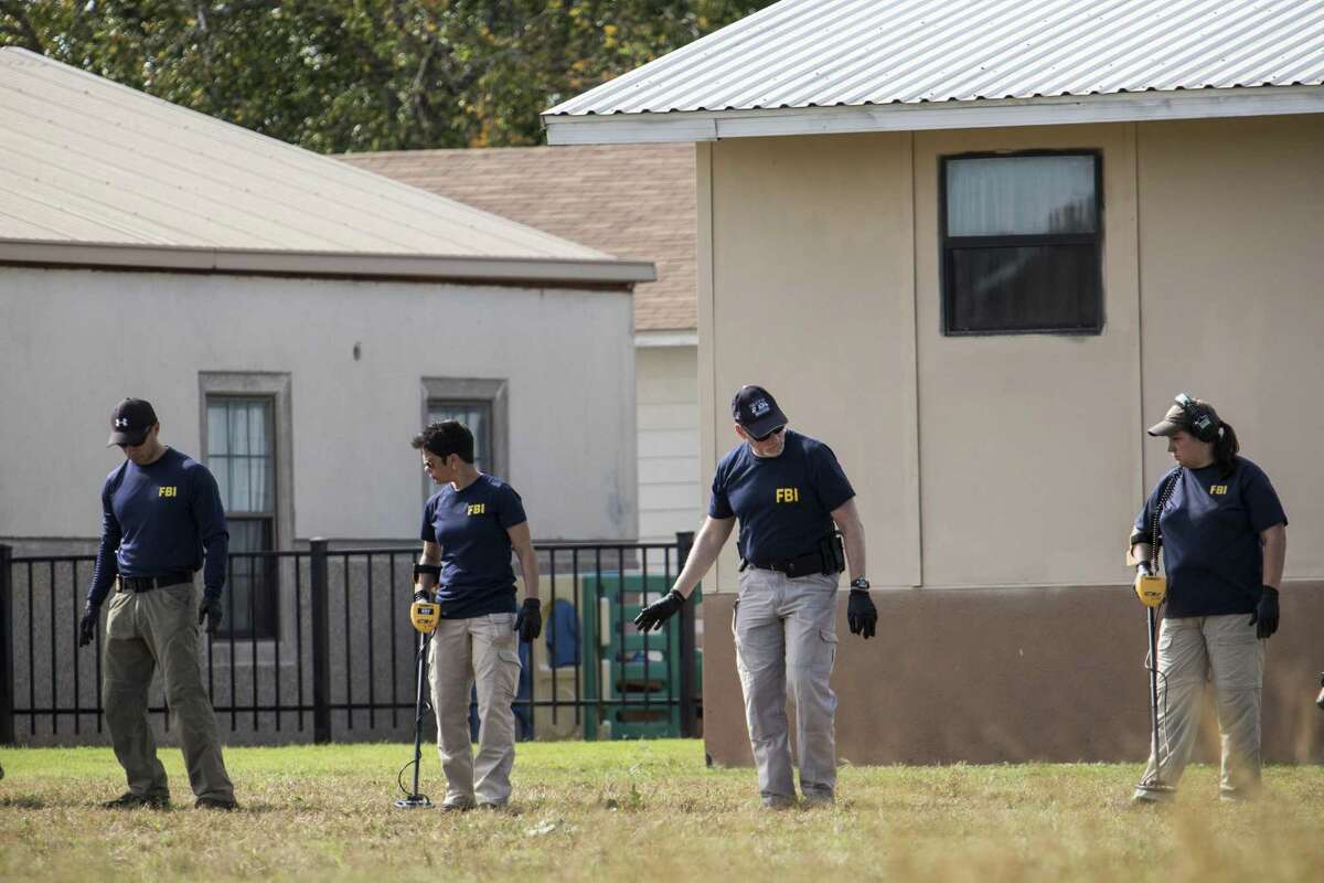 FBI personnel use metal detectors as the investigation of the mass shooting continued Monday in Sutherland Springs, Texas.