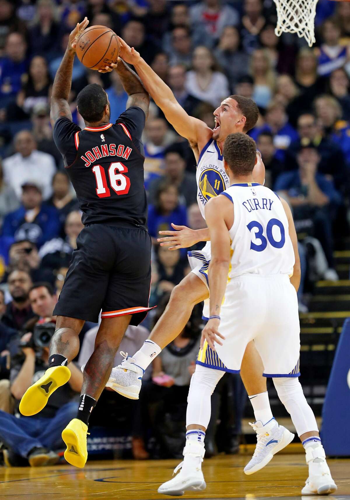 Golden State Warriors' Klay Thompson blocks a shot by Miami Heat's James Johnson in 1st quarter during NBA game at Oracle Arena in Oakland, Calif., on Monday, November 6, 2017.