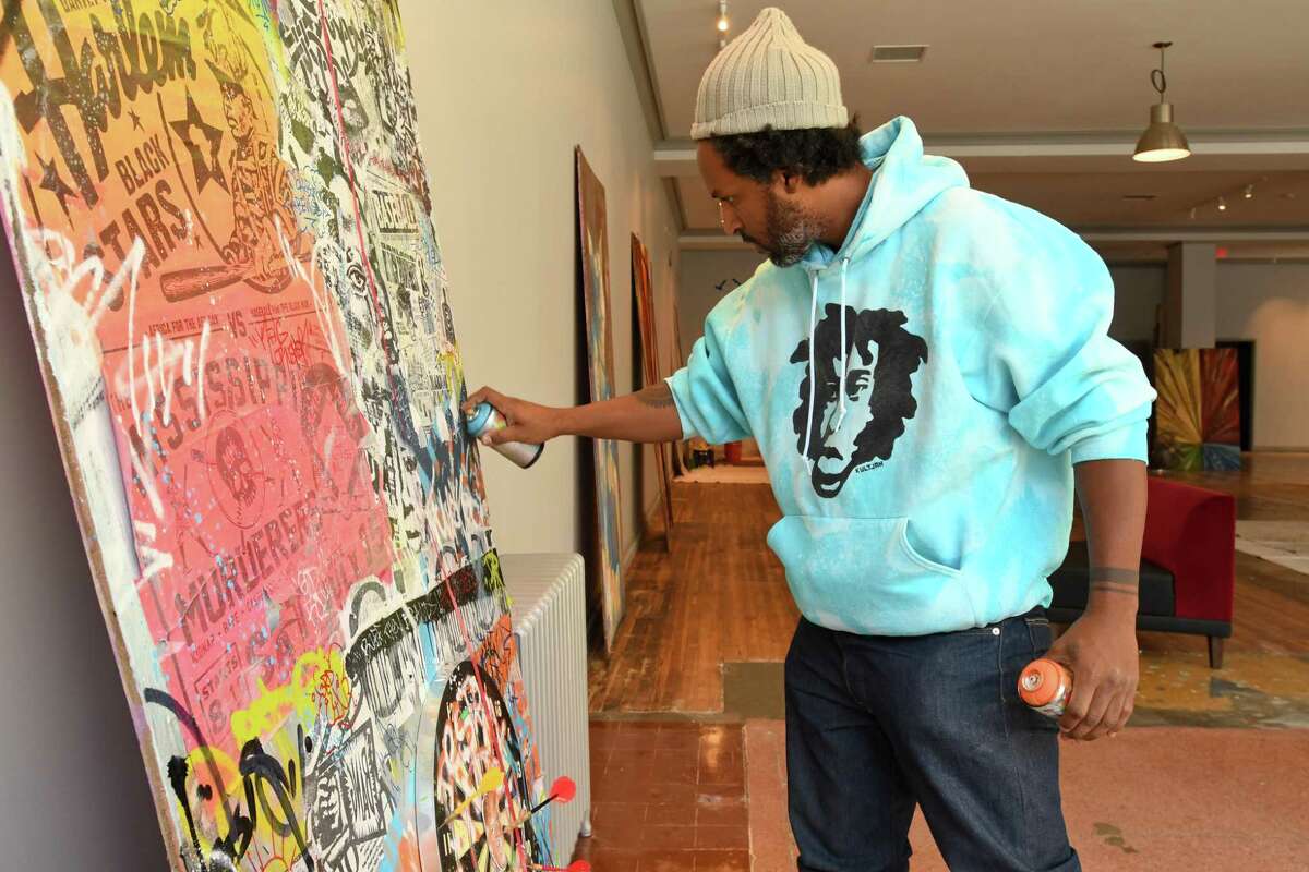 Jahmane works on his artwork, “Mentalchemy 25,” for the first show at the new urban art gallery Blends in downtown Bridgeport.