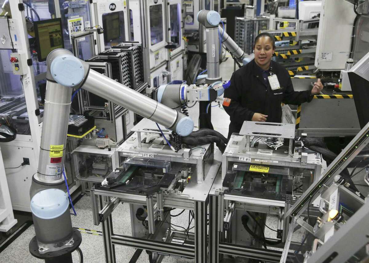Meghan Escalante works among several automated robotic arms at Continental’s Seguin manufacturing plant.