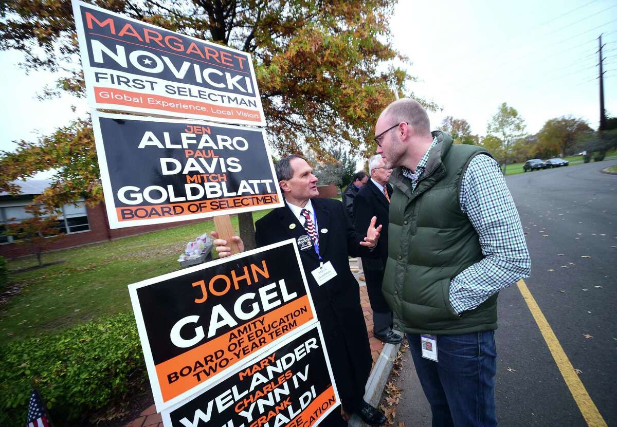 Board of Selectmen candidate Mitch Goldblatt (left) speaks with David Hudspeth outside of a polling place at the High Plains Community Center in Orange Tuesday.