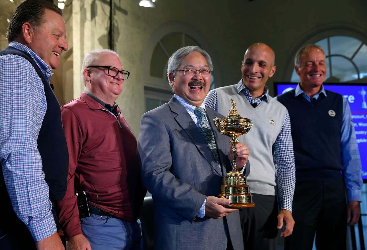 Mayor Ed Lee carries the Ryder Cup to the stage after PGA of America officials announce that the Olympic Club will host the 2028 PGA Championship and the Ryder Cup in 2032, in San Francisco, Calif. on Wednesday, Nov. 8, 2017. Standing with the mayor is, from left, PGA of America president Paul Levy, Olympic Club president Dan Dillon, Pete Bevacqua, PGA of America CEO and Kerry Haigh, the chief championships officer for PGA of America.
