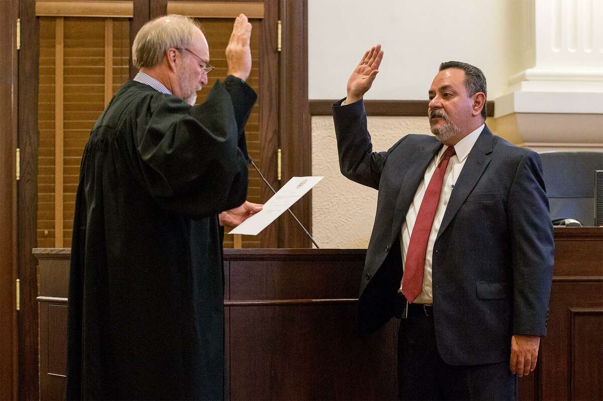 Judge Joey Contreras (right) is sworn in Wednesday as the new judge of the 187th state District Court by Judge Sid L. Harle in the Historic Presiding Courtroom of the Bexar County Courthouse.