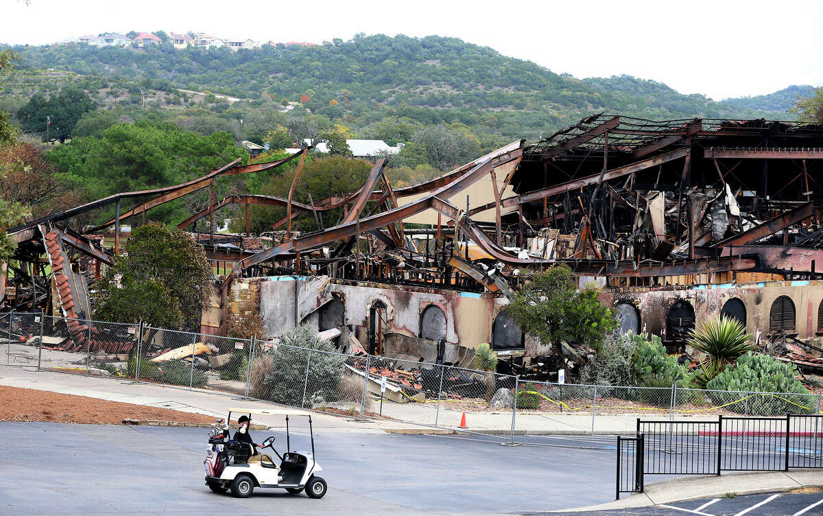 A man driving a golf cart passes the burned club house at the Tapatio Springs Hill Country resort near Boerne, Texas. A fire destroyed the building Saturday night November 4, 2017.