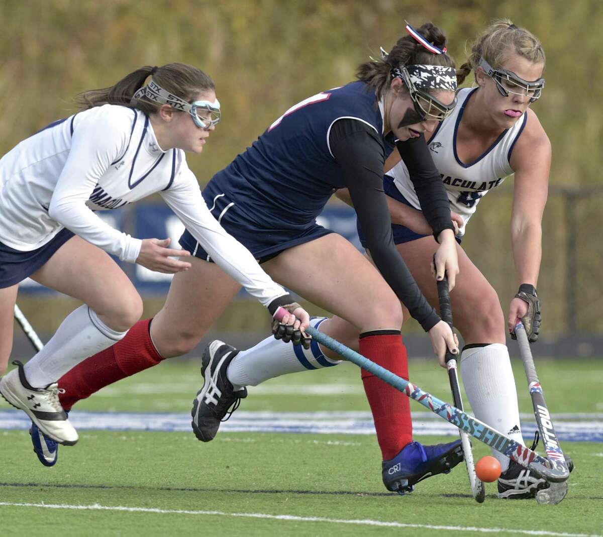 New Fairfield's Reagan Tenaglia (11) and Immaculate's Alexis Garden (17) and Madison Halas (14) fight for the ball in the girls State Class S Field Hockey playoff game between New Fairfield and Immaculate high schools, on Thursday afternoon, November 9, 2017, at Immaculate High School, in Danbury, Conn.