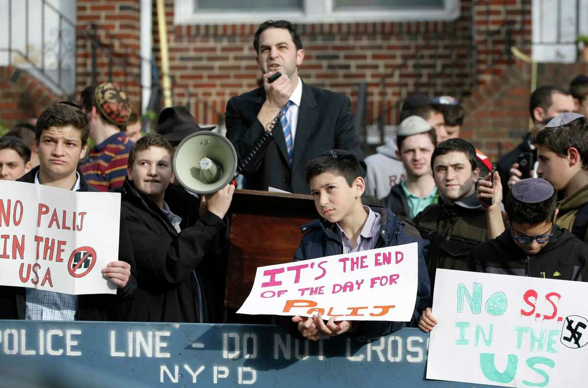Hillel Goldman, associate principal of the Orthodox Jewish Rambam Mesivta High School, speaks as he and students from the school protest across the street from the house of former Nazi concentration camp guard Jakiw Palij, 94, who worked as a guard at the Nazi German Trawniki SS camp in occupied Poland in 1943, Thursday, Nov. 9, 2017, in the Jackson Heights neighborhood of New York. About a hundred students from the school joined the protest to oust the Nazi war criminal from the United States on the 79th anniversary of Kristallnacht. (AP Photo/Kathy Willens) ORG XMIT: NYKW103