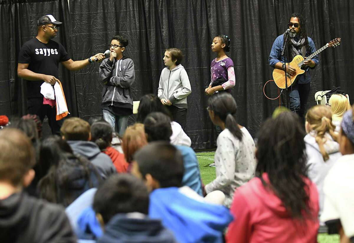 Author and poet Kwame Alexander, left, holds a literary pep rally with Schenectady City School District students at the Schenectady Armory on Thursday, Nov. 9, 2017 in Schenectady, N.Y. Musician Randy Preston, right, plays guitar and sings. (Lori Van Buren / Times Union)