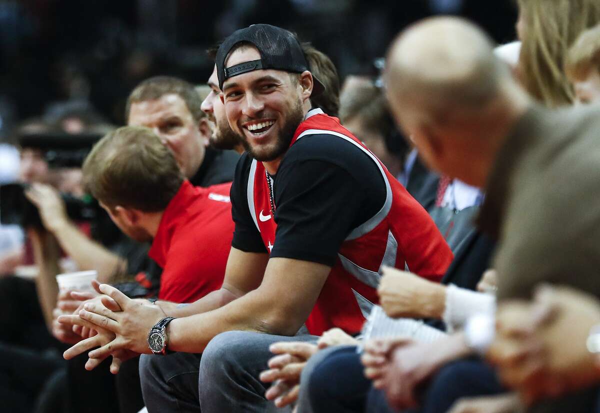 Houston Astros center fielder George Springer smiles at a fan as he sits courtside during a Rockets-Cavs game this season.