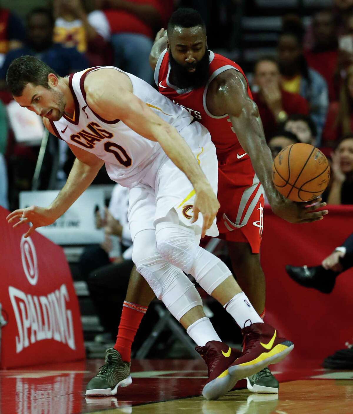 Rockets guard James Harden, right, pulls a surprise attack from behind to steal the ball away from Cavaliers forward Kevin Love during the first half at Toyota Center on Thursday night.