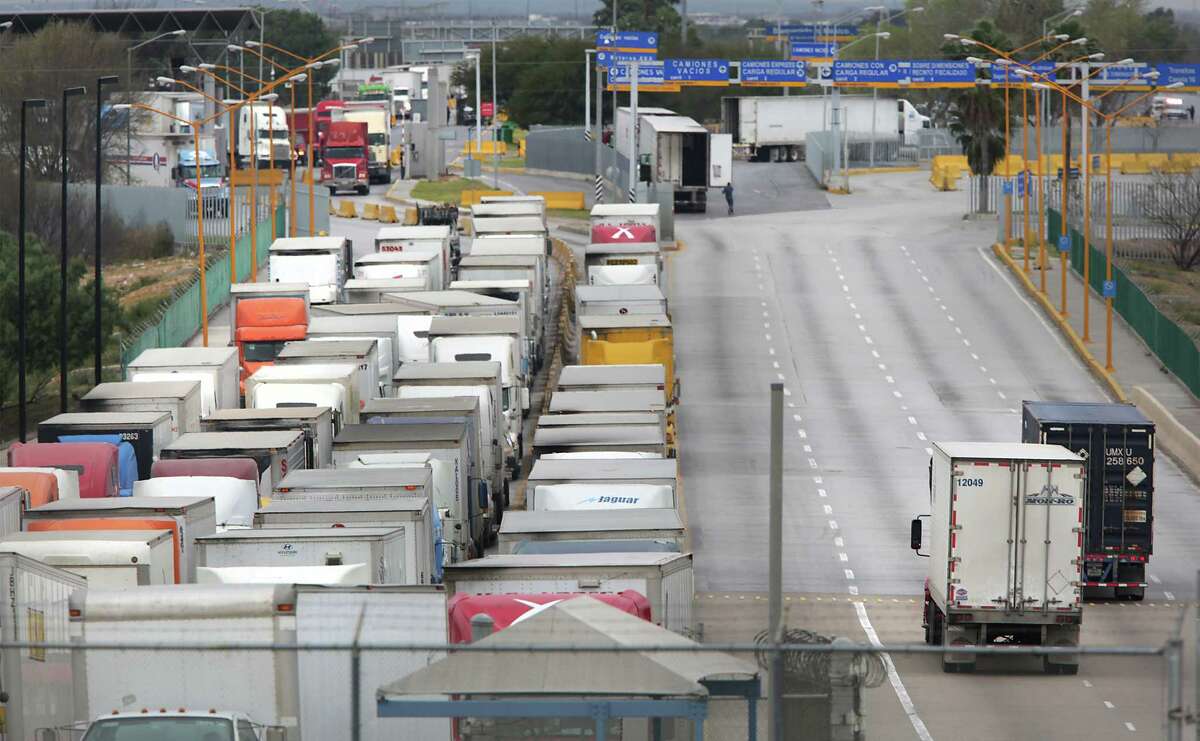 Two trucks, right, leave the United States as a long line of traffic waits to enter the U.S. from Mexico one morning at the World Trade Bridge in Laredo. ﻿The traffic is usually reversed in the evening.
