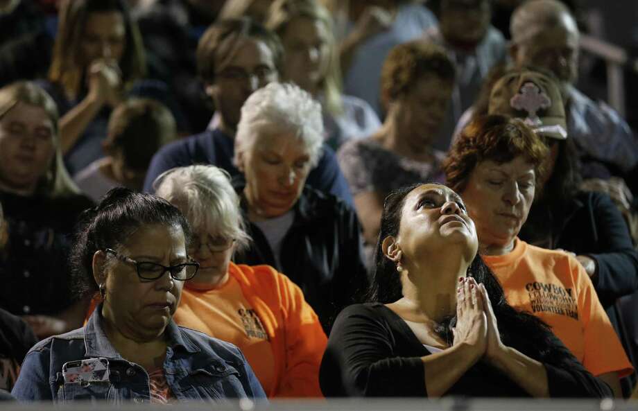 A mourner clasps her hands in prayer during a community memorial service at La Vernia High School's football stadium in the aftermath of the shooting tragedy at First Baptist Church in Sutherland Springs, Texas on Tuesday, Nov. 7, 2017. Photo: Kin Man Hui / ©2017 San Antonio Express-News