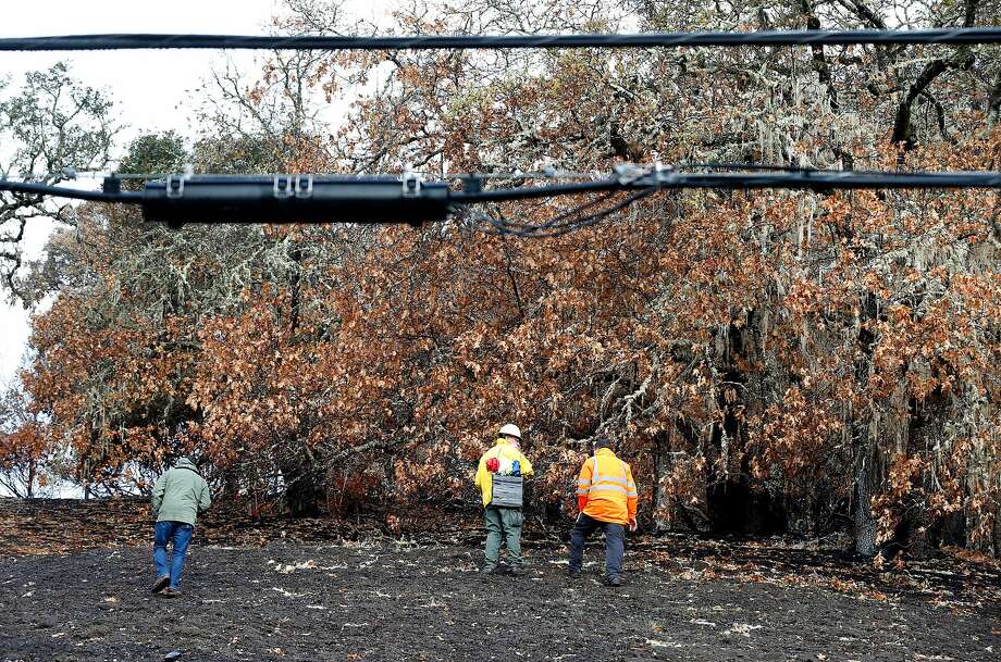 An inspection team walks on the charred property below power lines on Bennett Lane in Calistoga in November 2017, where authorities believe the Tubbs Fire originated. Photo: Paul Chinn / The Chronicle