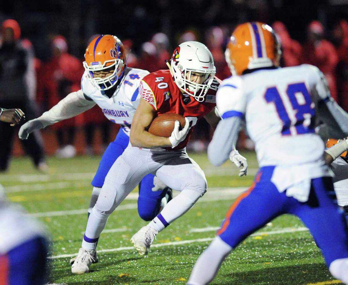 Greenwich running back Tysen Comizio (40) powers passed Danbury defenders Juan Jimenez (14) and Ronell Hopkins (18) to score a touchdown on a first-quarter run Friday night in Greenwich.