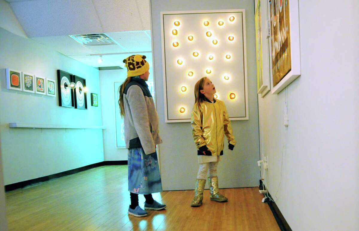 Charlotte Joergensen, 10, and her little sister Isobel, 8, browse artwork on display during he Bridgeport Art Trail's open studio hours for local artists at the Arcade Mall in Bridgeport, Conn., on Friday 10, 2017.