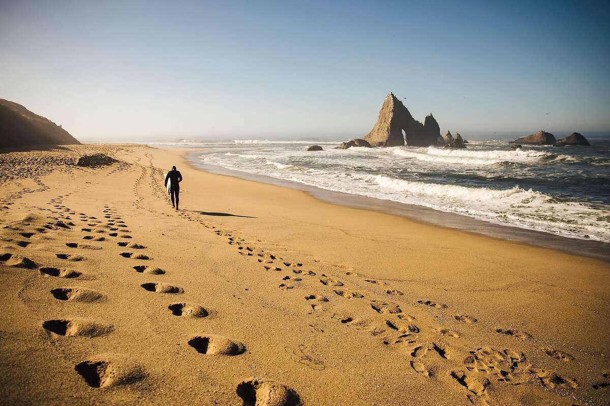 Jameson Kenway walks back to his car for work after an hour of surfing at Martins Beach in Half Moon Bay, Calif. Thursday, October 26, 2017.