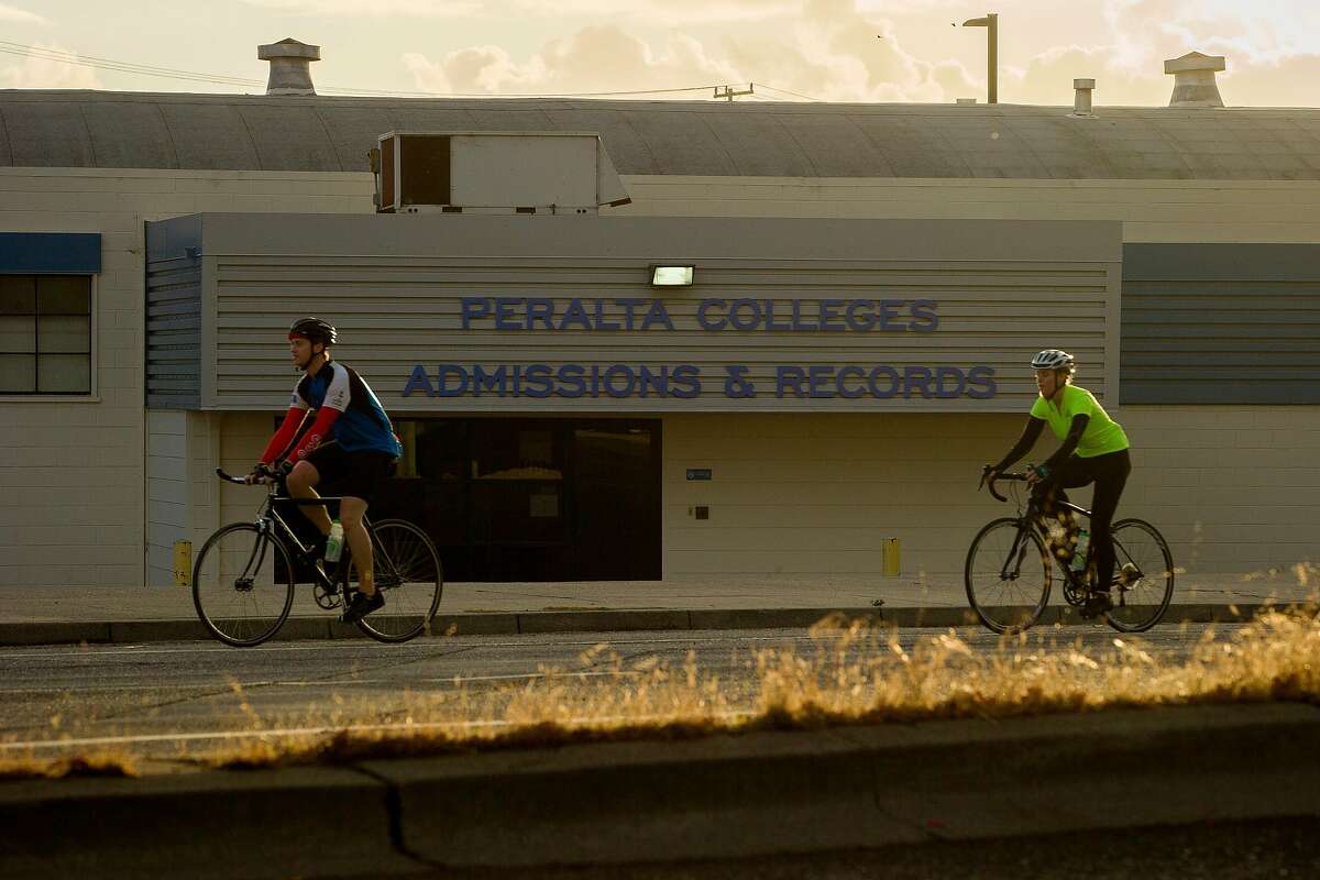 Bicyclists ride past the Peralta Colleges headquarters on Friday, Nov. 10, 2017, in Oakland, Calif. The Oakland A's are proposing a new stadium at the Peralta Community College District headquarters near Laney College.