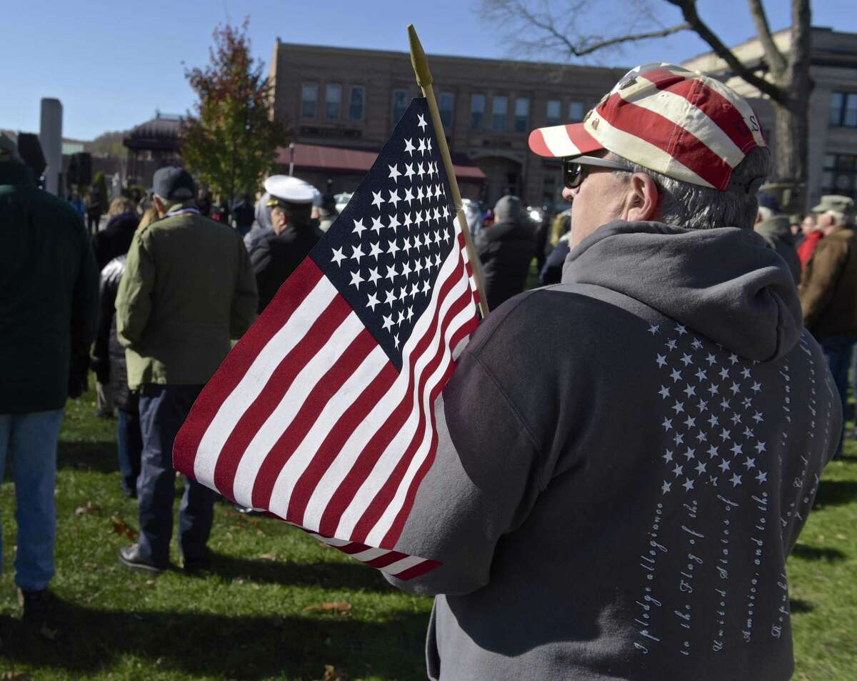 Mark E. Rosato, of New Milford, holds a flag and listens to a speaker during the annual New Milford Veterans Day Ceremony, held on 11/11 at 11am on the New Milford Town Green. Saturday morning, November 11, 2017, in New Milford, Conn. Rosato father Louis A. Rosato was a U.S. Army WWII veteran who served in Europe.