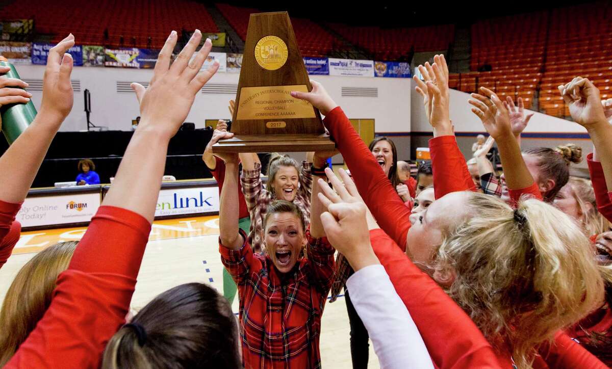 The Woodlands head coach Terri Wade raises the Region II-6A championship trophy after the Lady Highlanders defeated College Park 3-1 at Johnson Coliseum, Saturday, Nov. 11, 2017, in Huntsville.