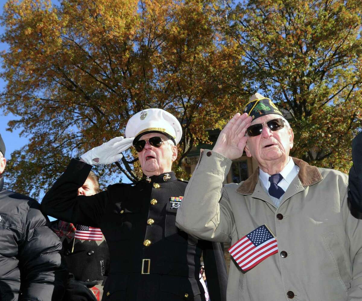 United States Marine Corps veteran Jim Larkin, 86, of Greenwich, who served in the Korean War, left, and Vin Masi, 90, also of Greenwich, who served in the U.S. Navy during WW II, salute the American Flag during the Greenwich Veterans Day Ceremony on Greenwich Avenue and at the War Memorials in Greenwich on Saturday.